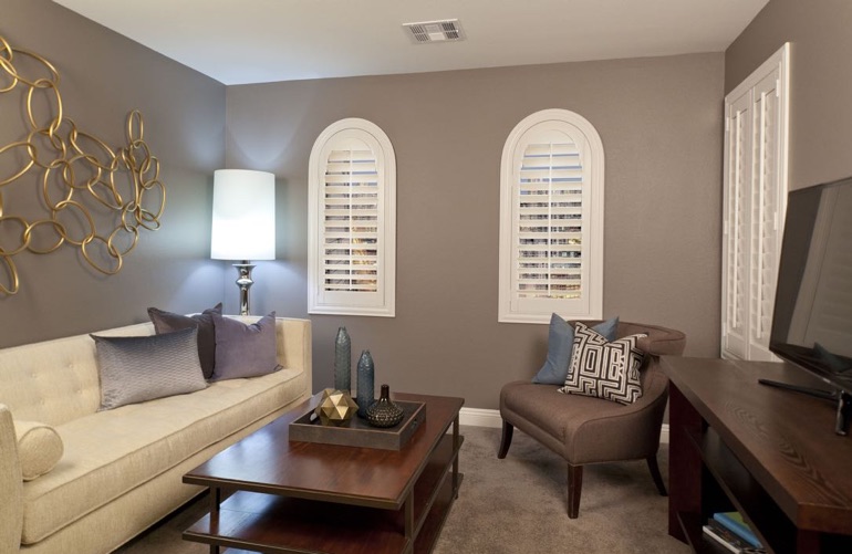 Family room with plantation shutters on arched windows and rectangular window